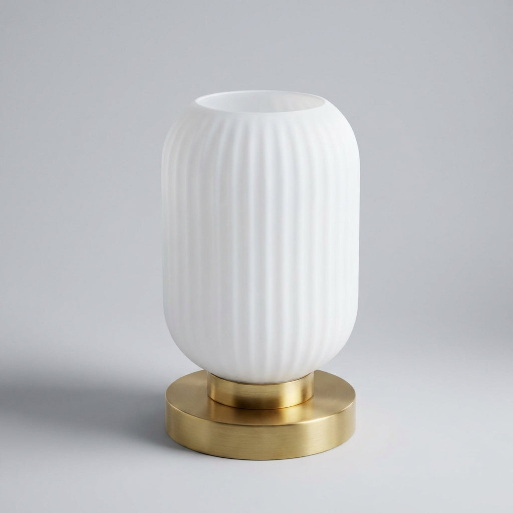 Stylish Glintora ribbed glass table lamp on a nightstand, providing a warm glow for modern bedroom decor.