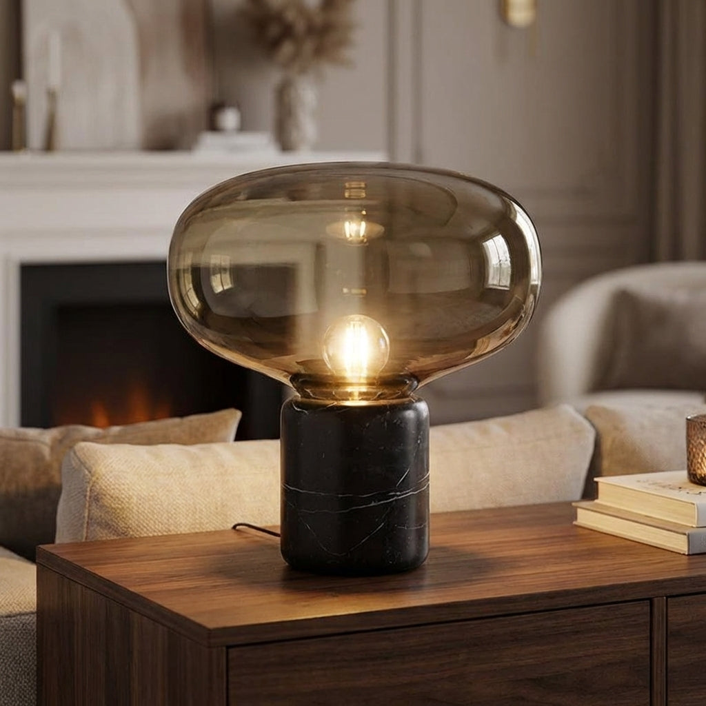 Modern sculptural table lamp, Aurablock, with marble base and glass shade for ambient light.