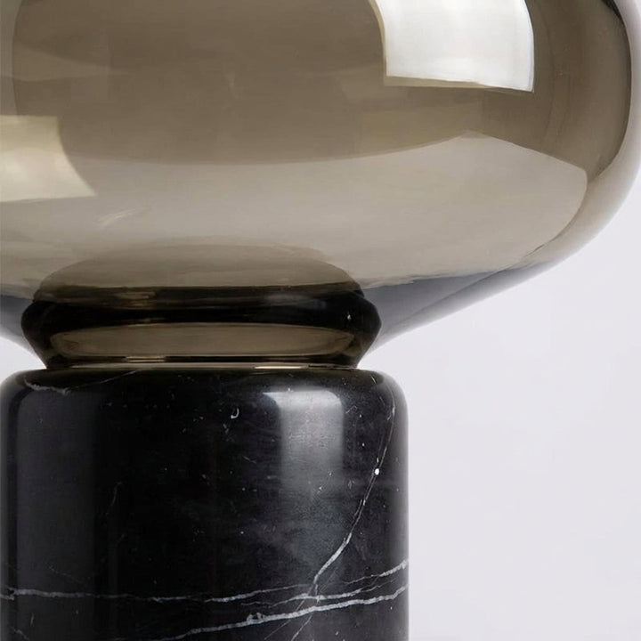 Designer table lamp, Aurablock, showcasing a modern sculptural form and round glass shade.