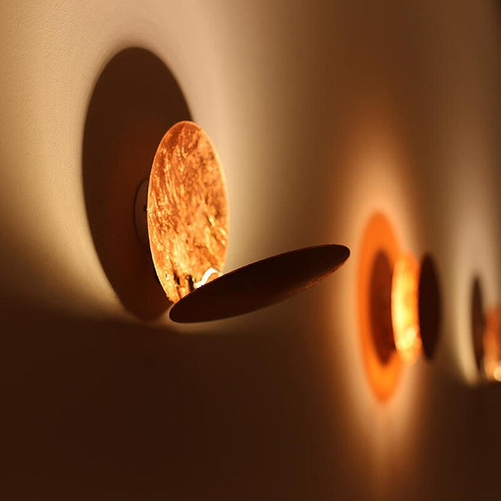 Decorative eclipse wall light, metallic gold finish, perfect for contemporary decor.