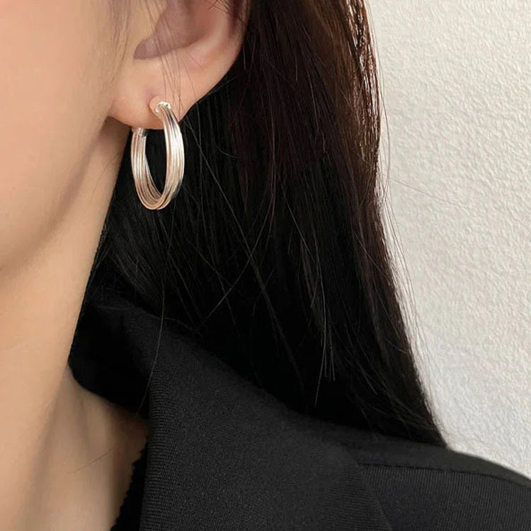 Chic contemporary women's sterling silver hoop earrings with an elegant layered lines design. Modern jewelry.