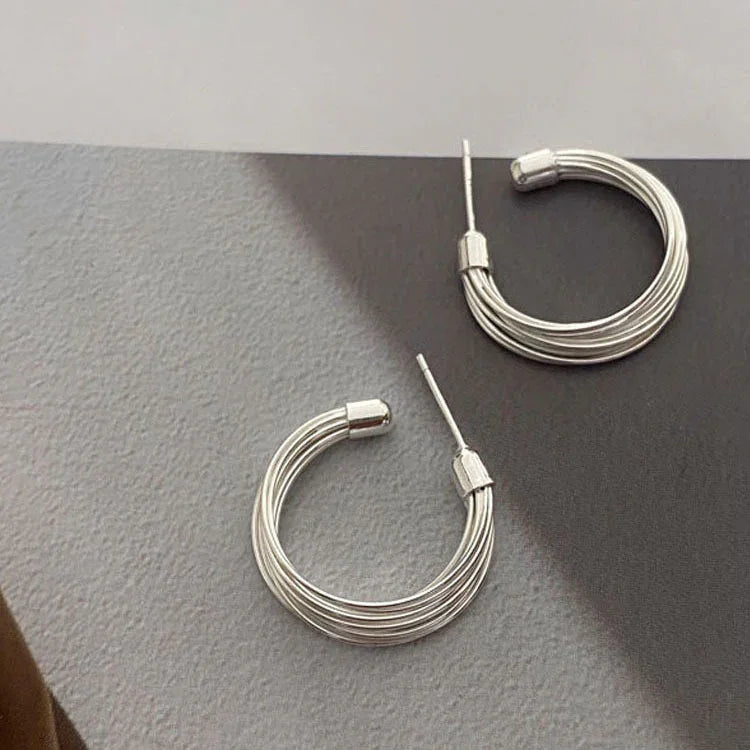Unique women's layered lines hoop earrings in sterling silver. Modern abstract design, adding chic style.