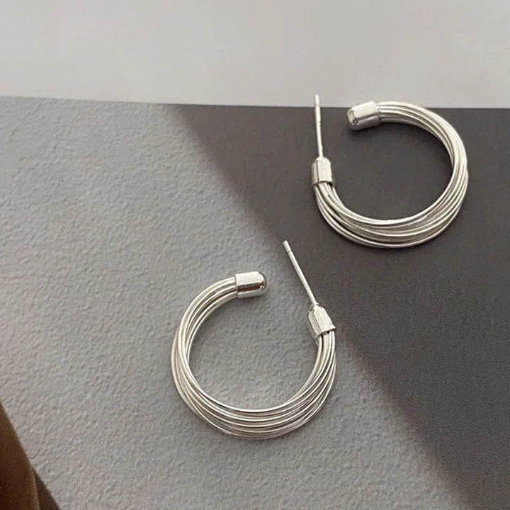Unique women's layered lines hoop earrings in sterling silver. Modern abstract design, adding chic style.