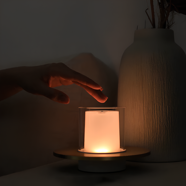 Gold LumiFlame LED candle lamp on a tabletop, demonstrating its use as modern ambient lighting