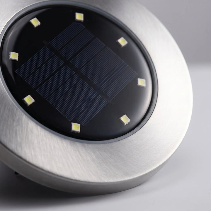 Discreet in-ground solar lights provide ambient glow for garden, lawn, and walkway safety.