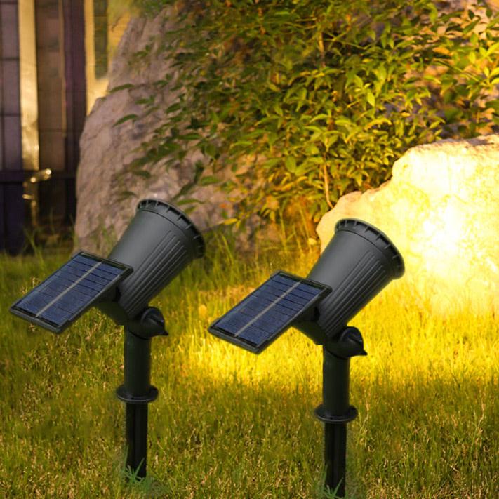 Energy-efficient solar garden spot with adjustable head, illuminating a flower bed at night, LumaSpot design