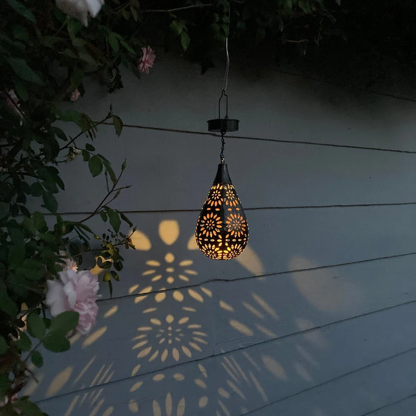 Weatherproof solar powered outdoor hanging lamp, brightens gardens & patios with soft, automatic light.