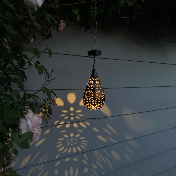 Weatherproof solar powered outdoor hanging lamp, brightens gardens & patios with soft, automatic light.