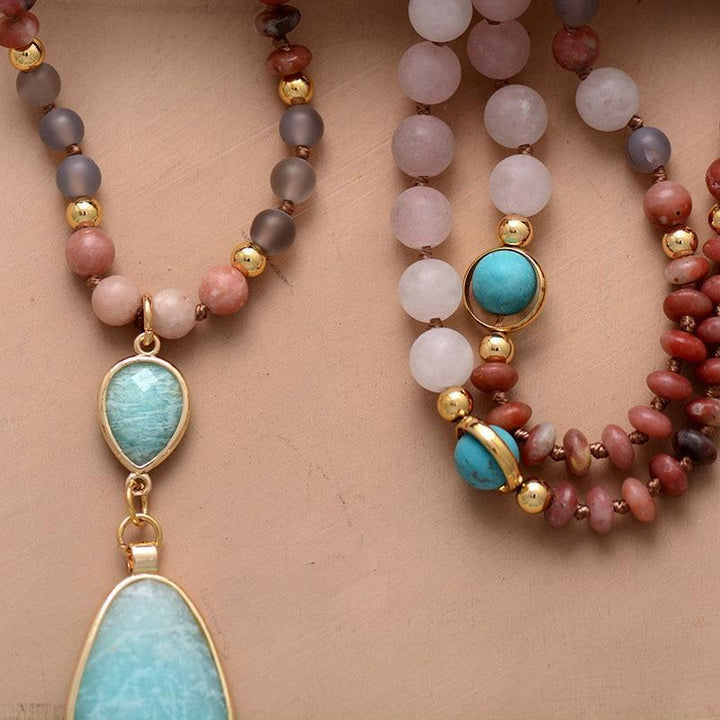 Close-up of a pastel gemstone mala necklace, showcasing rose quartz, jasper, and turquoise beads.