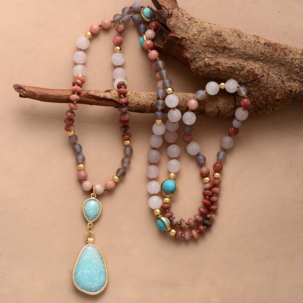 Beautiful pastel gemstone mala necklace with rose quartz, amazonite, and onyx beads on a white background.