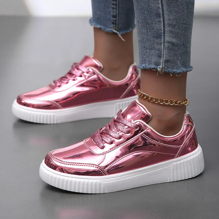 Shiny gold women's lace-up fashion sneakers, offering a chic, glossy look for trendy casual wear.