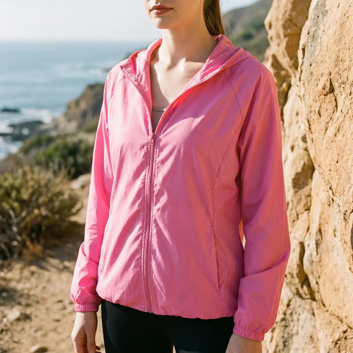 Pink women's lightweight hooded active jacket, perfect for outdoor activities, hiking, and travel. A packable windbreaker.
