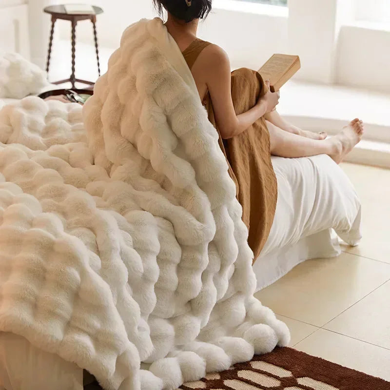 Plush cream faux fur blanket draped on a sofa, offering cozy comfort and luxurious home decor