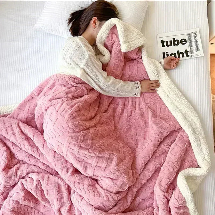 Comfortable bedding accessory: a thick, warm double-sided fleece and lambswool blanket draped over a sofa.