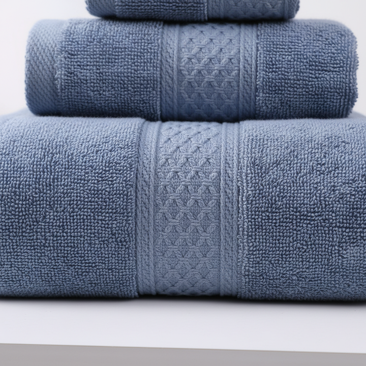 Stack of folded RelaxWrap unisex plush cotton bath towels, ideal for home decor