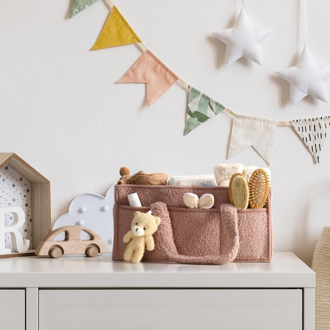 Beige sherpa diaper caddy with a rattle and small toys, doubles as a toy organizer