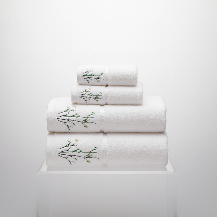 Arrangement of a complete white bamboo towel set: bath, hand, and face towels, ready for a luxurious bathroom experience.