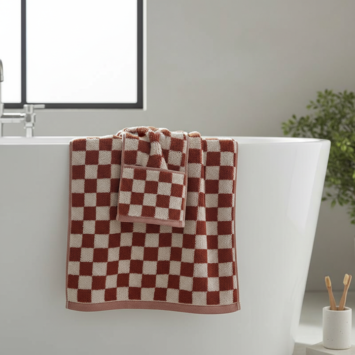 Plush white cotton bath towel set, featuring two bath towels and two hand towels, on a clean bathroom counter.