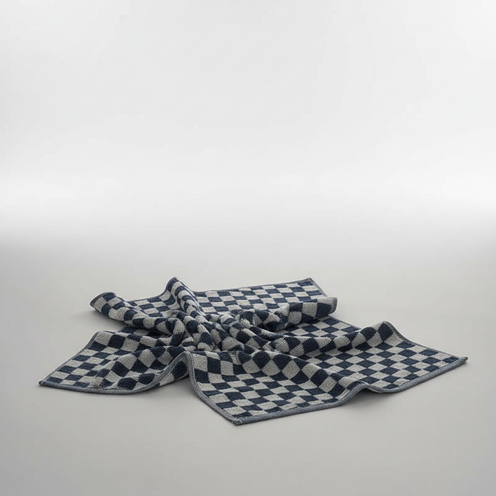 Collection of various sized soft cotton towels from the ShimmerTowel set, neatly folded for bathroom linen storage.