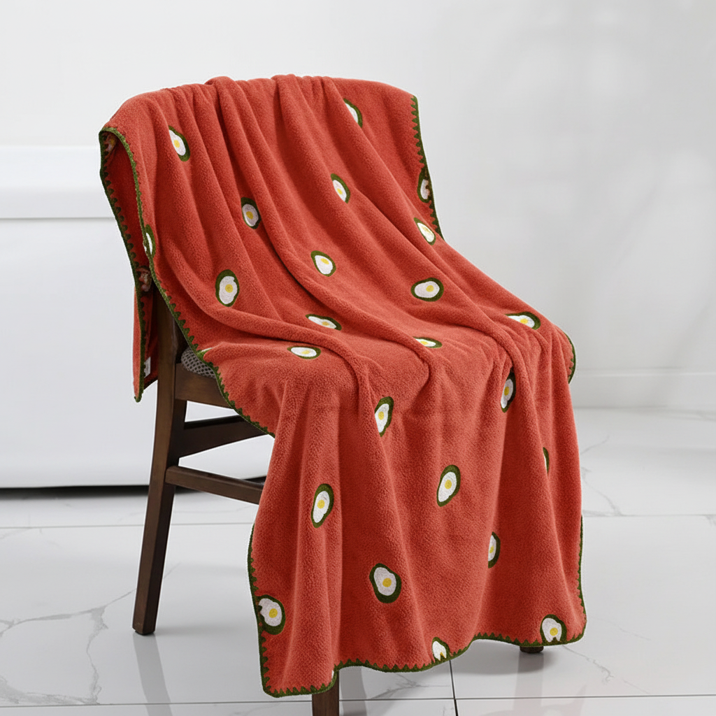 Stack of unisex luxury bath towels, showcasing beautiful fruit embroidery and soft texture.