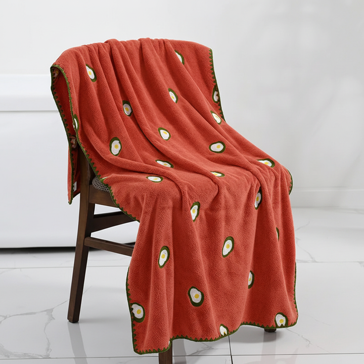 Stack of unisex luxury bath towels, showcasing beautiful fruit embroidery and soft texture.