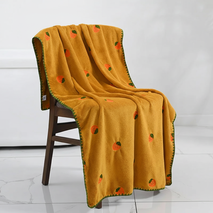 White luxury fruit embroidered bath towel draped, highlighting its soft, absorbent material.