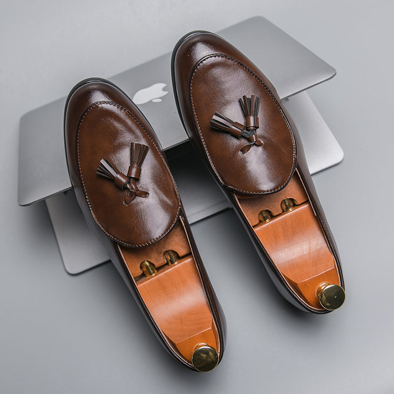 Polished black men's tassel loafers for formal occasions, offering slip-on comfort and style.