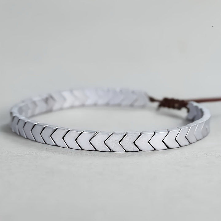 Sleek minimalist polished hematite beaded bracelet. Natural stone fashion accessory, versatile unisex design.
