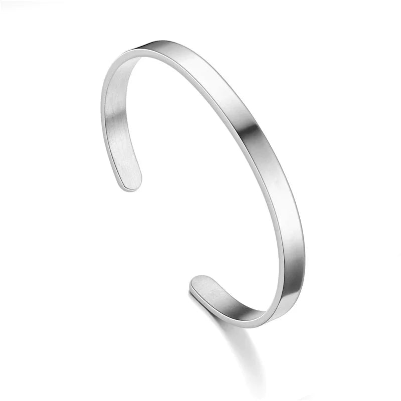Close-up of a polished stainless steel men's cuff bracelet, showcasing its modern minimalist design.