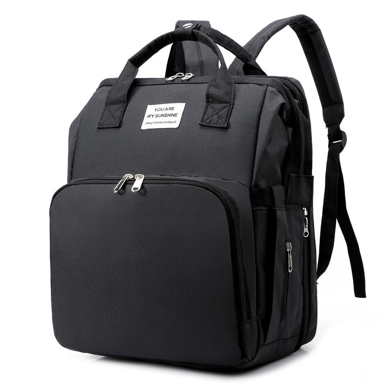 Portable baby changing bed and nappy bag backpack in grey, multi-function travel gear for moms.