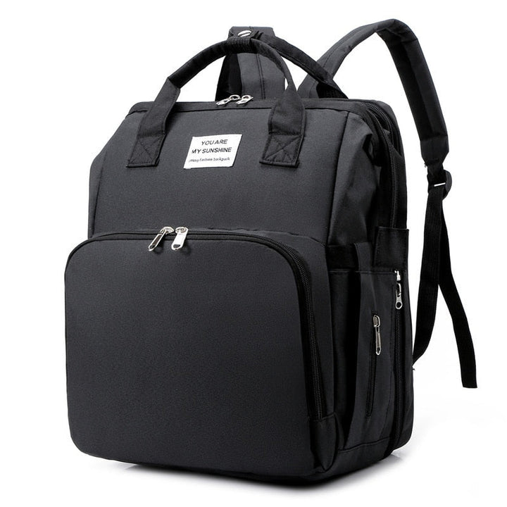 Portable baby changing bed and nappy bag backpack in grey, multi-function travel gear for moms.