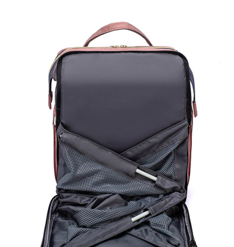 Portable baby bed and nappy bag combo, demonstrating its compact form and expansion capability.