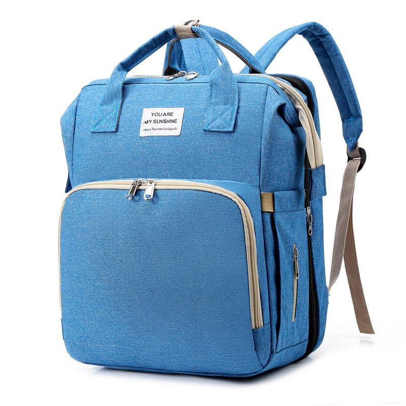 Baby travel backpack opening into an integrated portable changing station with sunshade, waterproof.
