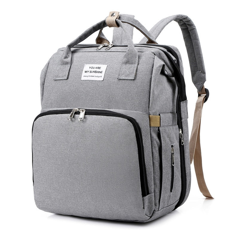 Multi-function baby bag for travel, expanding into a safe, soft portable bed with easy access storage.