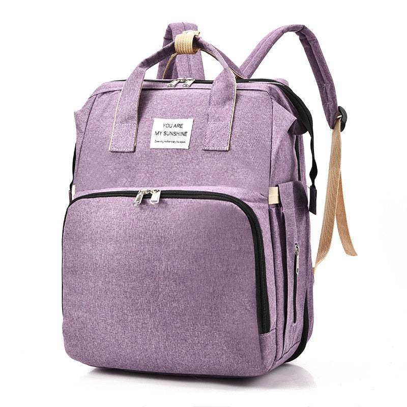 Grey baby travel backpack with padded straps, side pockets, transforming into a changing bed.