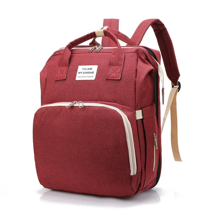 Compact nappy bag backpack and portable baby bed, ideal for on-the-go parents, parenting essentials.