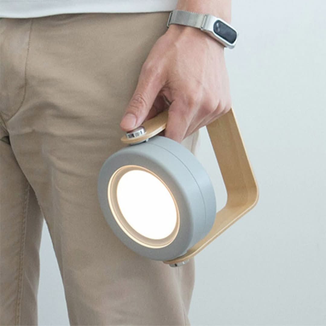 Adjustable Solvian LED lamp, portable and dimmable, with a warm light glow and elegant wooden base.