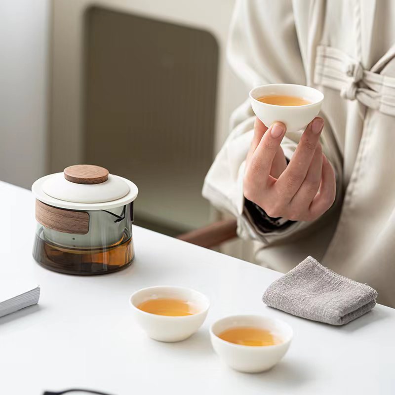 Stylish ceramic & glass travel tea set, complete with three cups and a teapot, perfect for outdoor adventures.