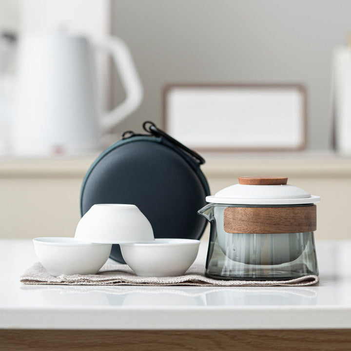Durable travel tea set with a secure carrying case, ceramic cups, and glass infuser teapot for safe transport.