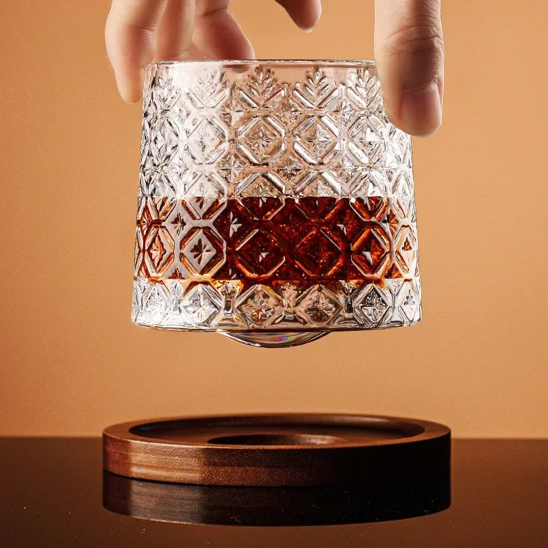 A pair of heavy-base crystal whiskey glasses displayed on a sleek, natural wood stand, perfect for home bar enthusiasts.