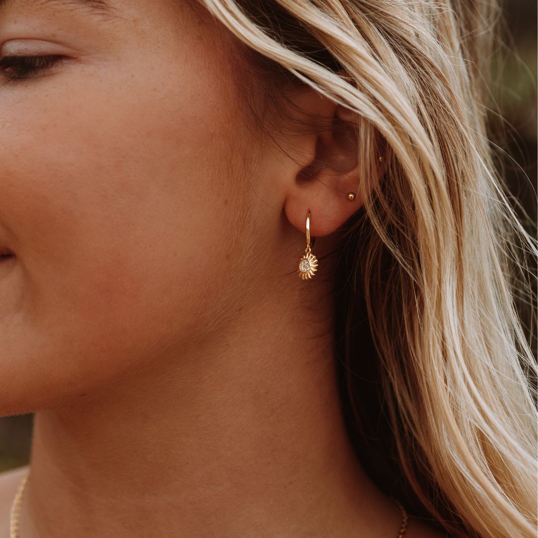 Elegant women's celestial sun drop earrings in gold & silver. Stylish jewelry accessory for modern fashion.