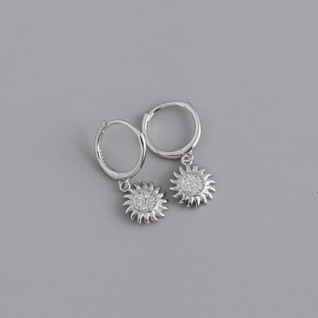 Stunning women's sun drop earrings crafted from gold and silver. Elegant celestial jewelry accessory.