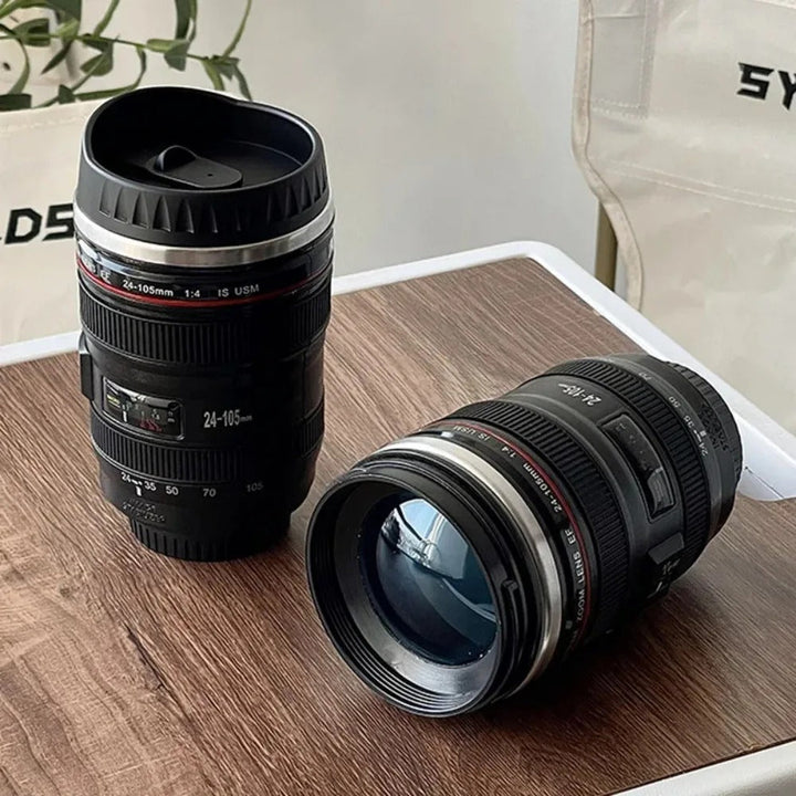 Realistic black camera lens coffee mug (FocusMug), stainless steel interior, for photographers and gadget fans.