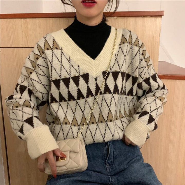 Woman wearing a beige loose fit aesthetic sweater. Everyday chic long sleeve pullover for comfortable casual fashion.