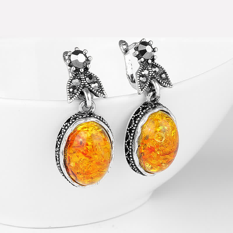 Delicate retro flower earrings featuring a warm amber stone, set in shimmering silver.