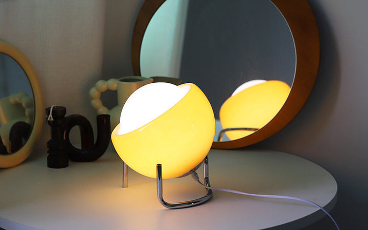 Stylish retro glass table lamp illuminating a modern bedside table setup