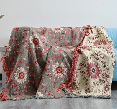 Close-up of a reversible cotton blanket showcasing detailed Scandinavian bird and floral design.