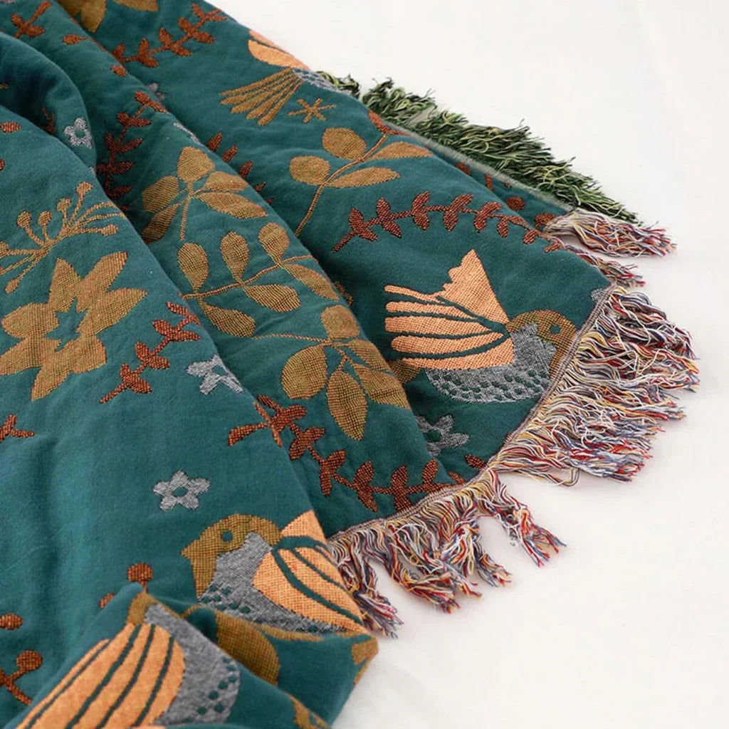 Folded reversible cotton blanket with a charming bird pattern, ready to enhance Scandinavian home decor.
