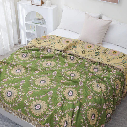 Textured cotton blanket with a reversible bird and botanical pattern, an elegant addition to home textiles.