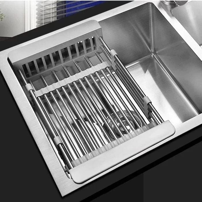 Stainless steel roll-up drying rack over kitchen sink, ideal for draining washed fruits and vegetables.